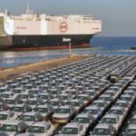 Archive photograph of vehicles at a port beside a BYD car carrier