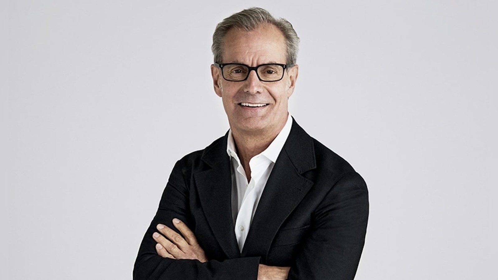 Portrait of Ciena CEO Gary Smith wearing glasses and a black blazer against a light background