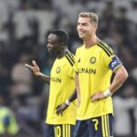 Cristiano Ronaldo standing on the pitch in a yellow Al Nassr football kit