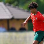 Young soccer player Cristiano Ronaldo Jr wearing a red Portugal national team jersey during a match