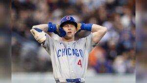 A Chicago Cubs baseball player with hands on his head looking frustrated on the field