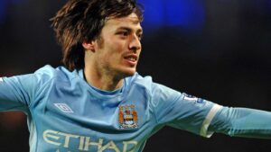 David Silva celebrating a goal wearing the light blue Manchester City jersey with Etihad sponsor
