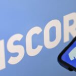 Close up of the Discord logo and a mobile phone displaying the app interface