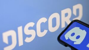 Close up of the Discord logo and a mobile phone displaying the app interface