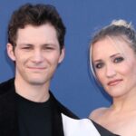 Actors Emily Osment and Montana Jordan posing together against a blue backdrop