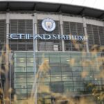 Exterior view of the Etihad Stadium featuring the Manchester City club crest and signage