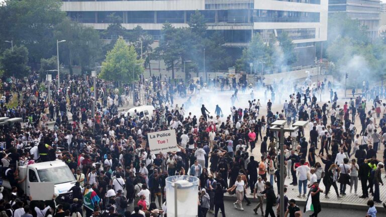 Large crowd of protesters gathering in a French city amid smoke and demonstrations