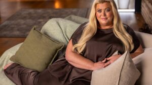 Gemma Collins sitting comfortably on a sofa with cushions during her documentary project interview