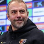 Barcelona manager Hansi Flick speaking during a press conference in front of a sponsor backdrop