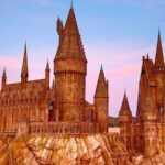 Detailed view of the majestic wizarding castle set against a colorful sunset sky