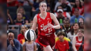 Caitlin Clark in a red Indiana Fever jersey dribbling a basketball on the court