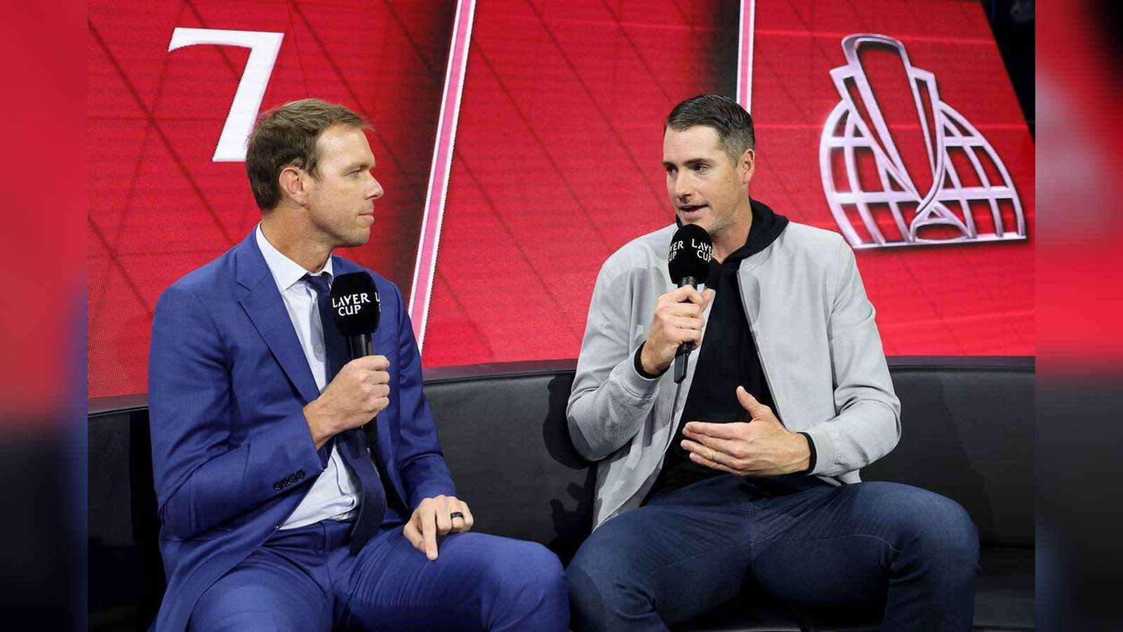 Former tennis players John Isner and Sam Querrey seated together holding microphones during an inter