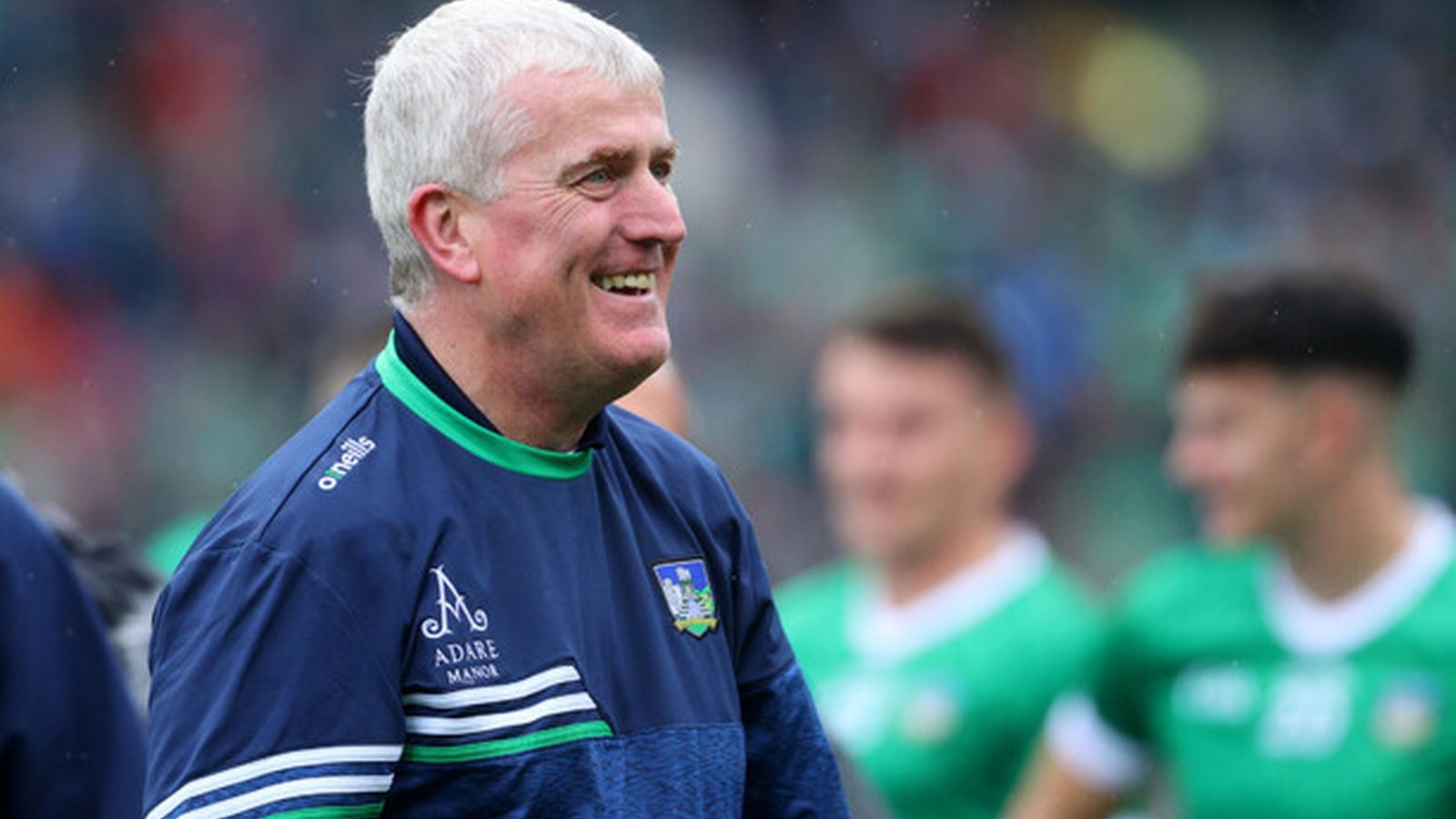 Limerick hurling manager John Kiely smiling outdoors wearing a blue and green training top