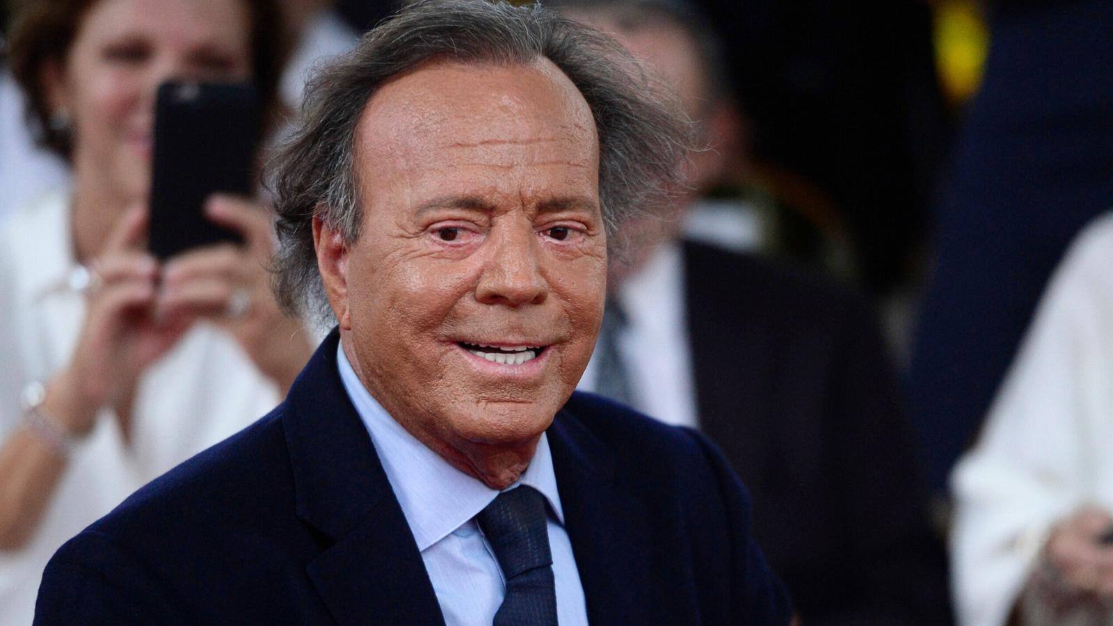 Close-up portrait of singer Julio Iglesias wearing a dark suit and tie