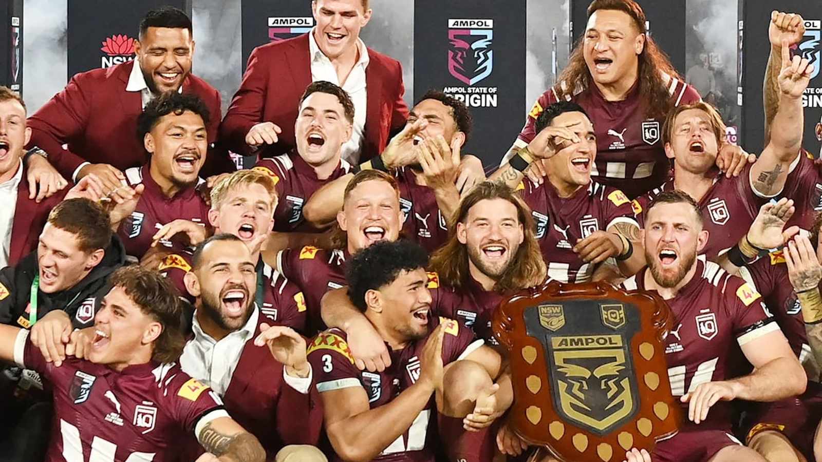 Junior Amone and his rugby teammates celebrating together with a shield trophy