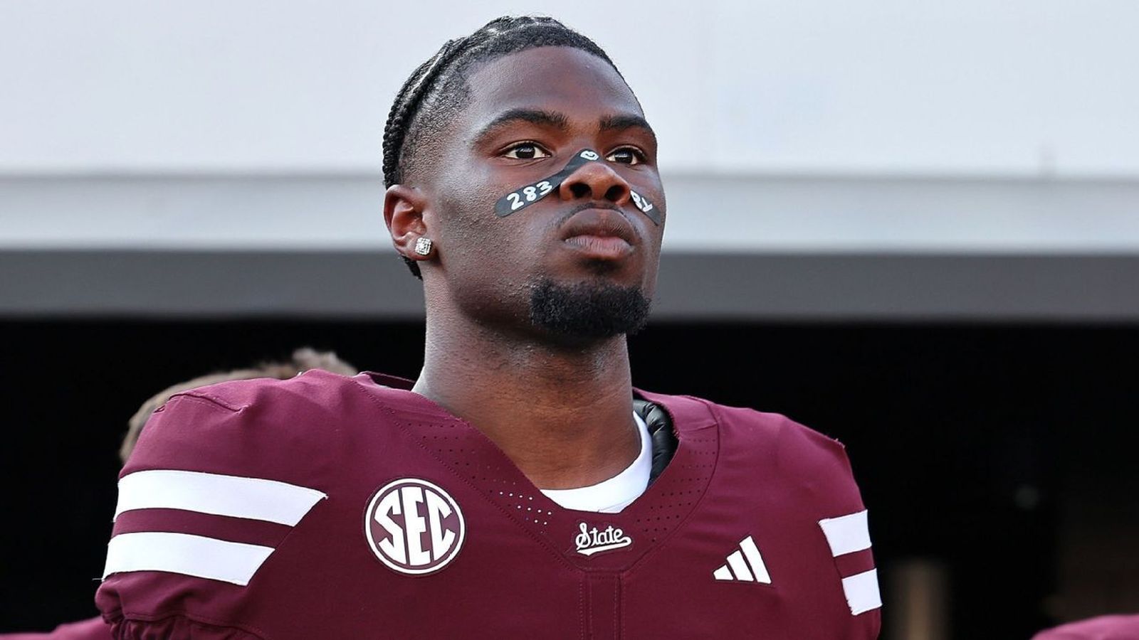 Close-up portrait of Mississippi State quarterback Kamario Taylor wearing a maroon jersey on the fie