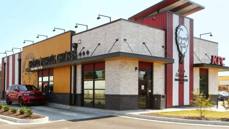 Exterior view of a modern KFC restaurant building with drive-thru and Colonel Sanders logo