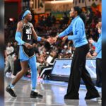 LaToya Sanders in blue coaching attire interacting with an Atlanta Dream basketball player on the co