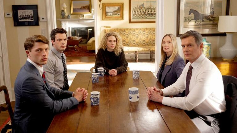 Cast members of the television series Line of Fire sitting around a wooden dining table