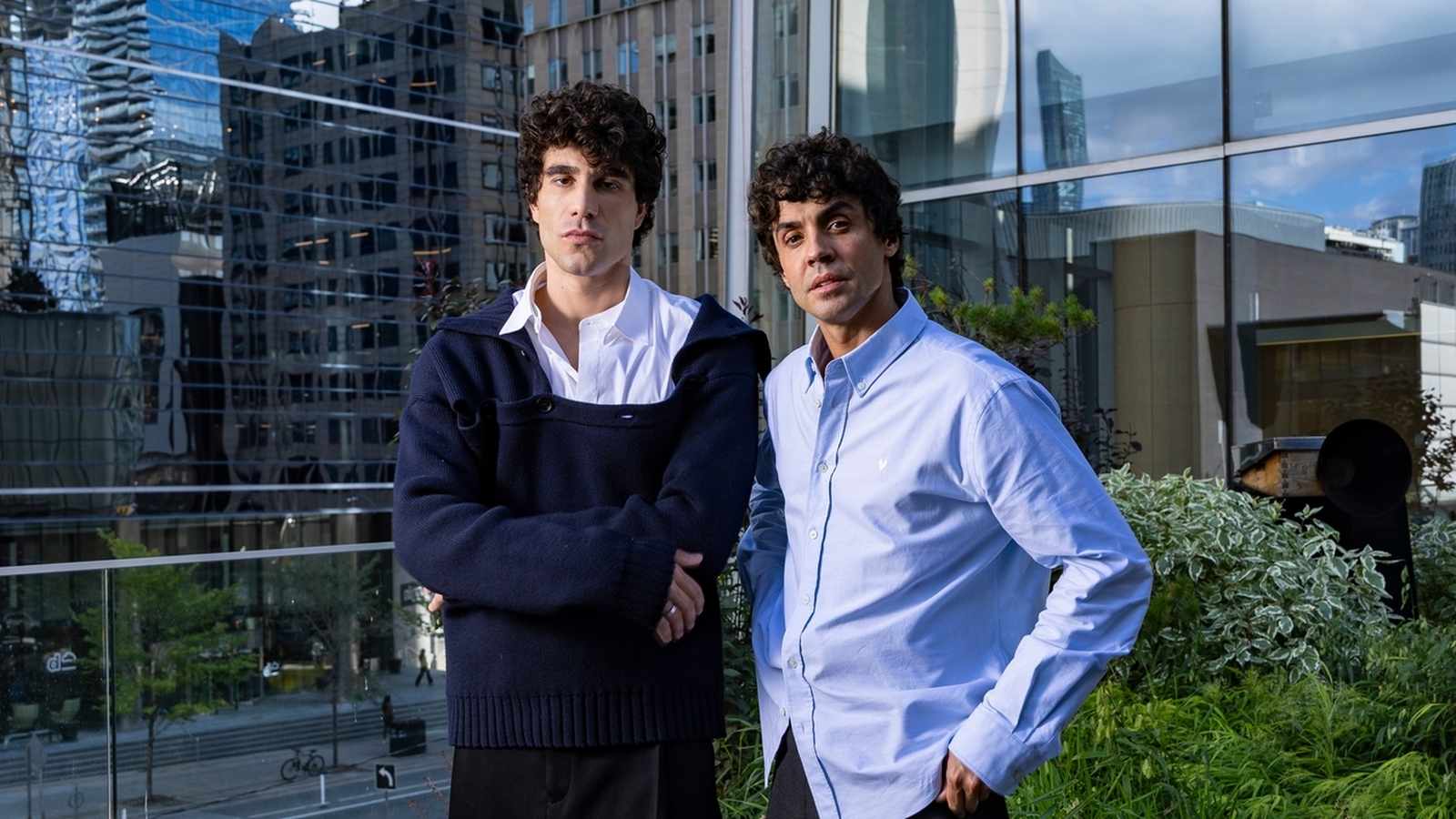 Spanish directors Javier Calvo and Javier Ambrossi posing together in front of a modern building