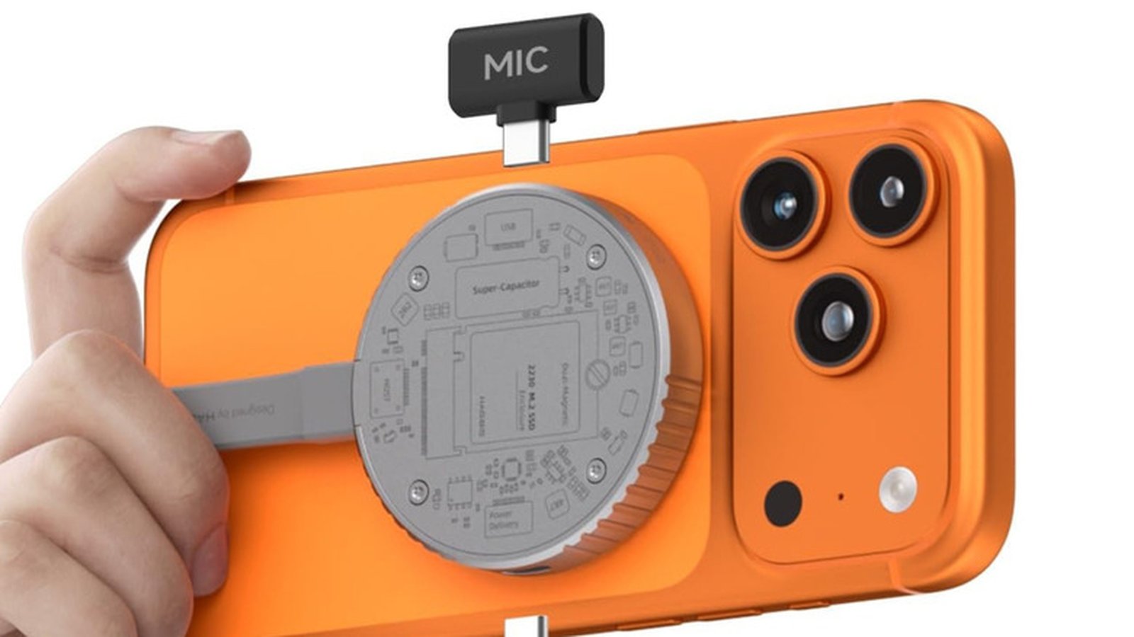 Close up of an orange smartphone with a circular MagSafe accessory and attached microphone