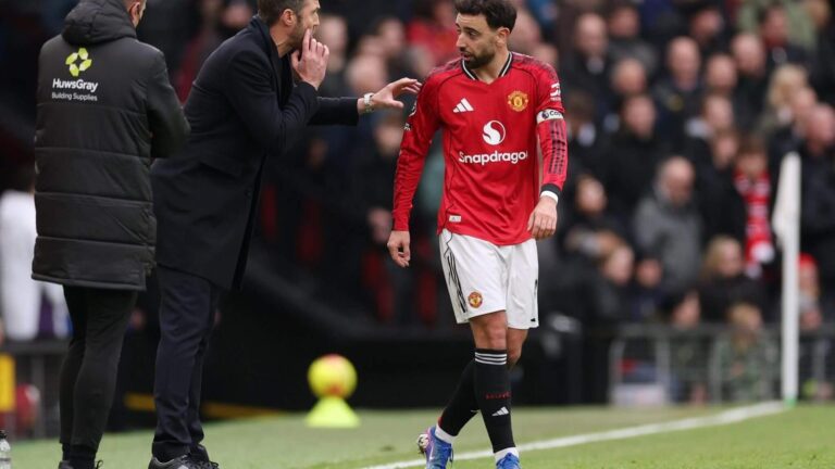 Michael Carrick talking to Bruno Fernandes on the football pitch during a match