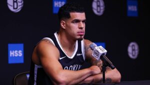 Michael Porter Jr. sitting at a microphone wearing a Brooklyn Nets jersey during a press conference