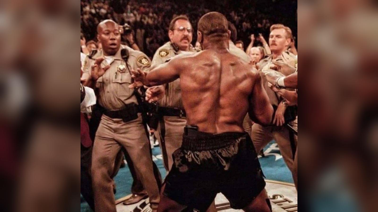 Police officers swarm the ring as Mike Tyson and Evander Holyfield fight during their 1997 rematch.