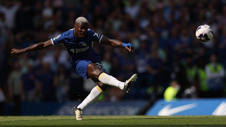 Moises Caicedo wearing a blue Chelsea kit kicking a football during a match