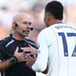 Referee talking to Morgan Rogers wearing number 17 during a football match