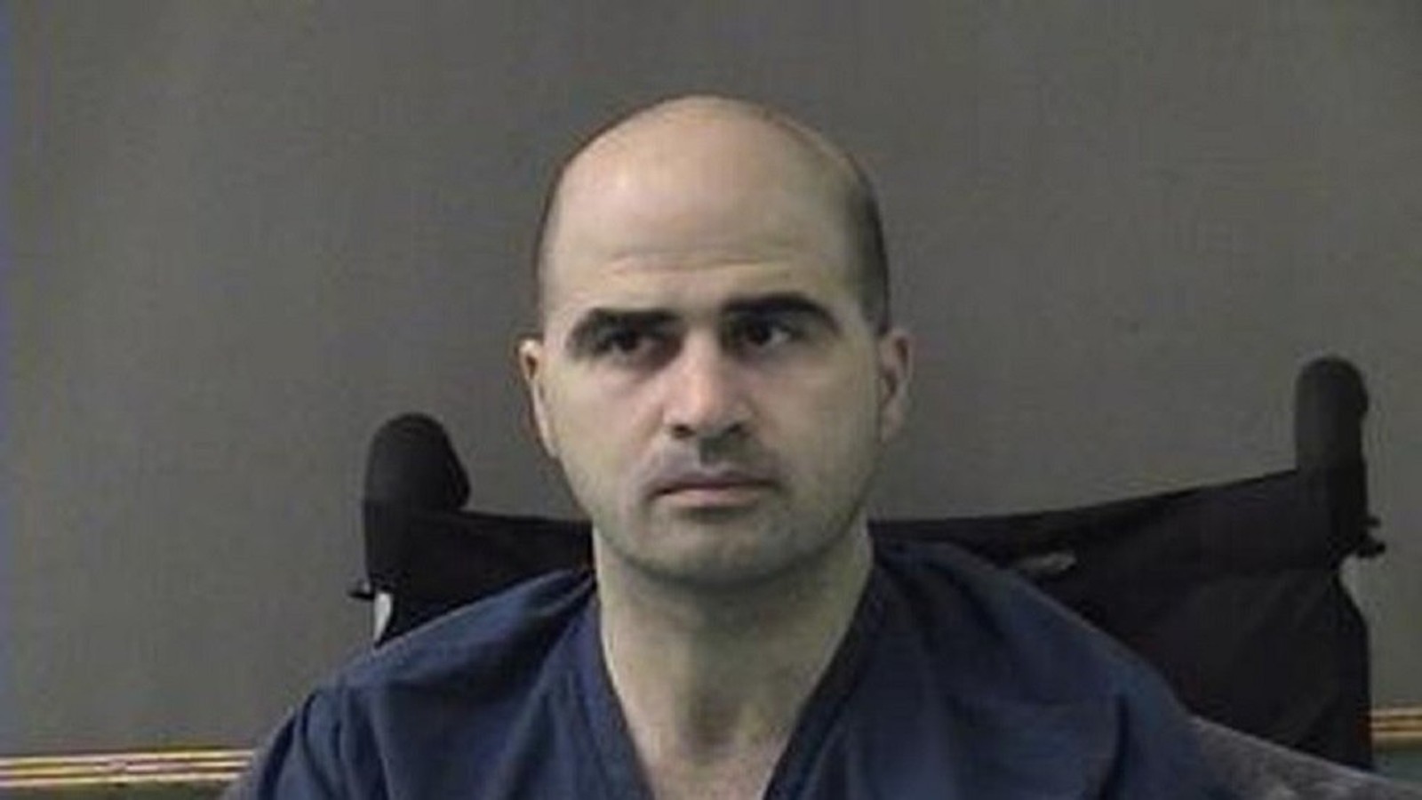 Portrait of Nidal Hasan sitting in a wheelchair wearing a blue shirt