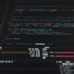 Close-up of computer screen displaying programming code in a dark mode terminal editor