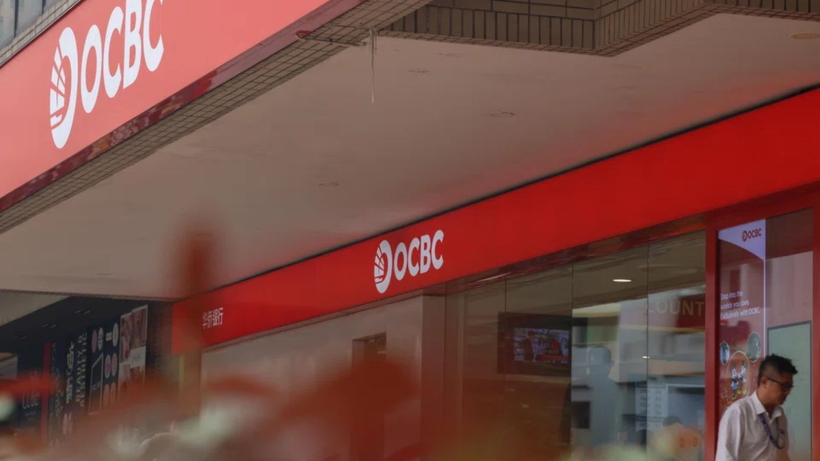 Exterior view of an OCBC bank branch with prominent red company signage and building facade