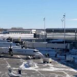 Commercial airplanes parked at the terminal on a snowy tarmac at Ottawa International Airport