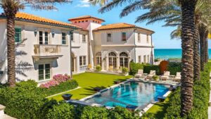 A large luxury Mediterranean-style mansion in Palm Beach featuring a swimming pool and ocean view