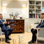 Hungarian politician Peter Magyar sitting in an armchair and speaking during an interview in an offi