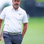 Professional golfer Phil Mickelson walking on a golf course holding a club