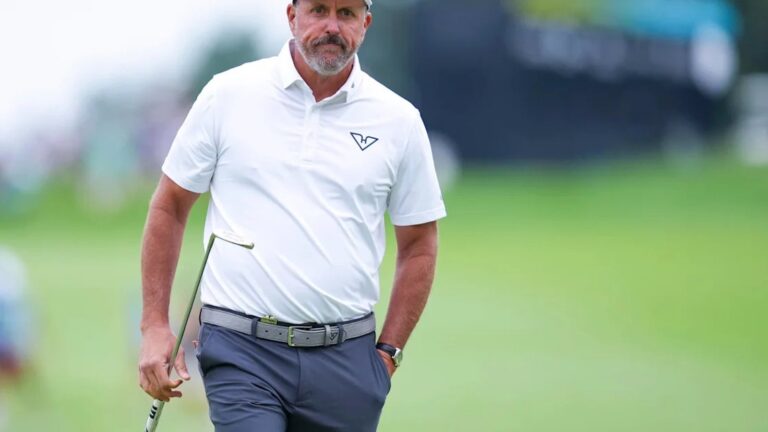 Professional golfer Phil Mickelson walking on a golf course holding a club