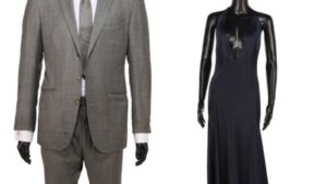 Mannequins displaying a grey Tom Ford suit and a black dress from James Bond films