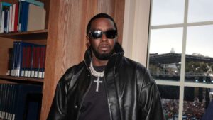 Sean Diddy Combs wearing dark sunglasses and a black leather jacket indoors