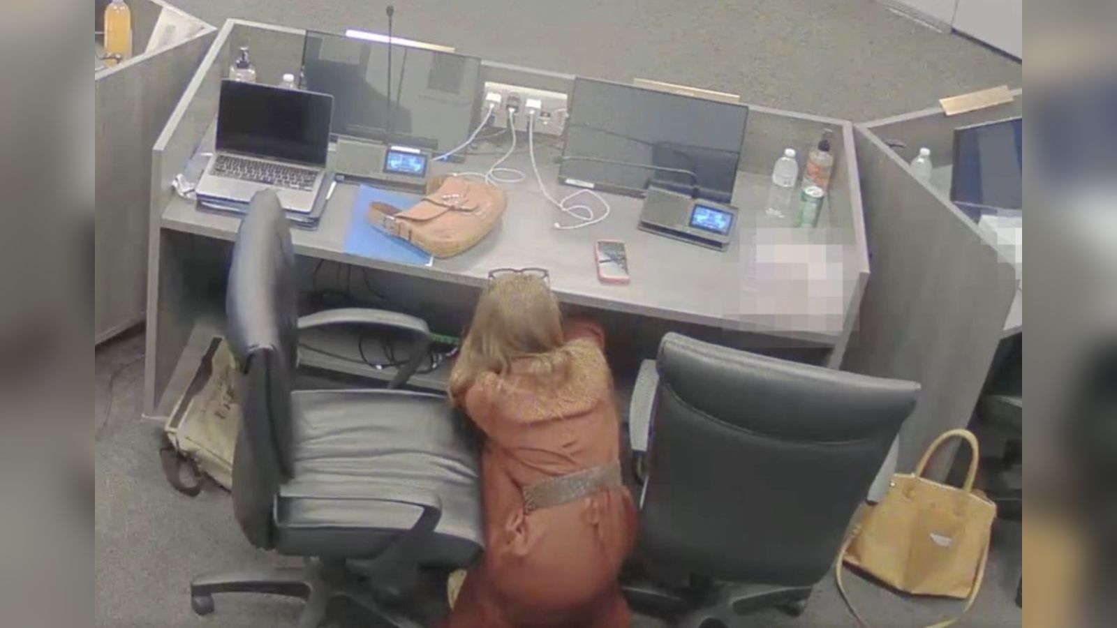 Surveillance camera view of a person crouched beneath a desk during the Temecula school board scanda