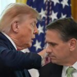 US Attorney General Todd Blanche listening alongside Donald Trump in front of American flags