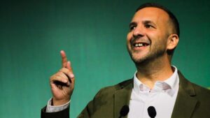 Zack Polanski smiling and gesturing while speaking at a Green Party conference