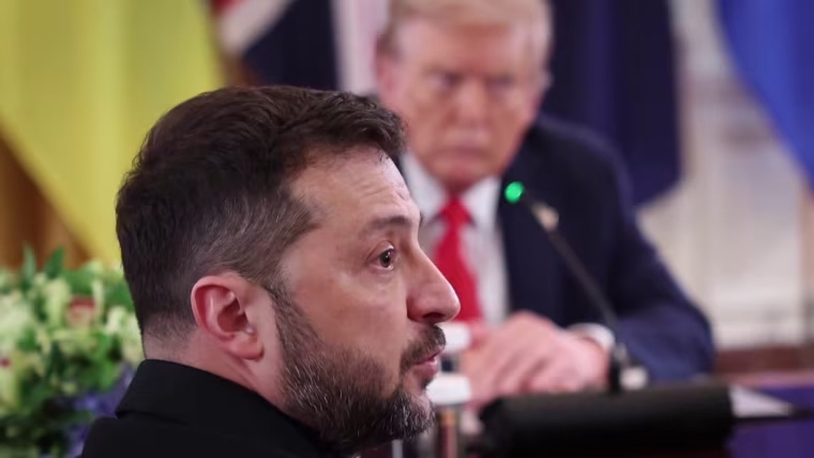 Ukrainian President Volodymyr Zelenskyy speaking with US President Donald Trump in the background